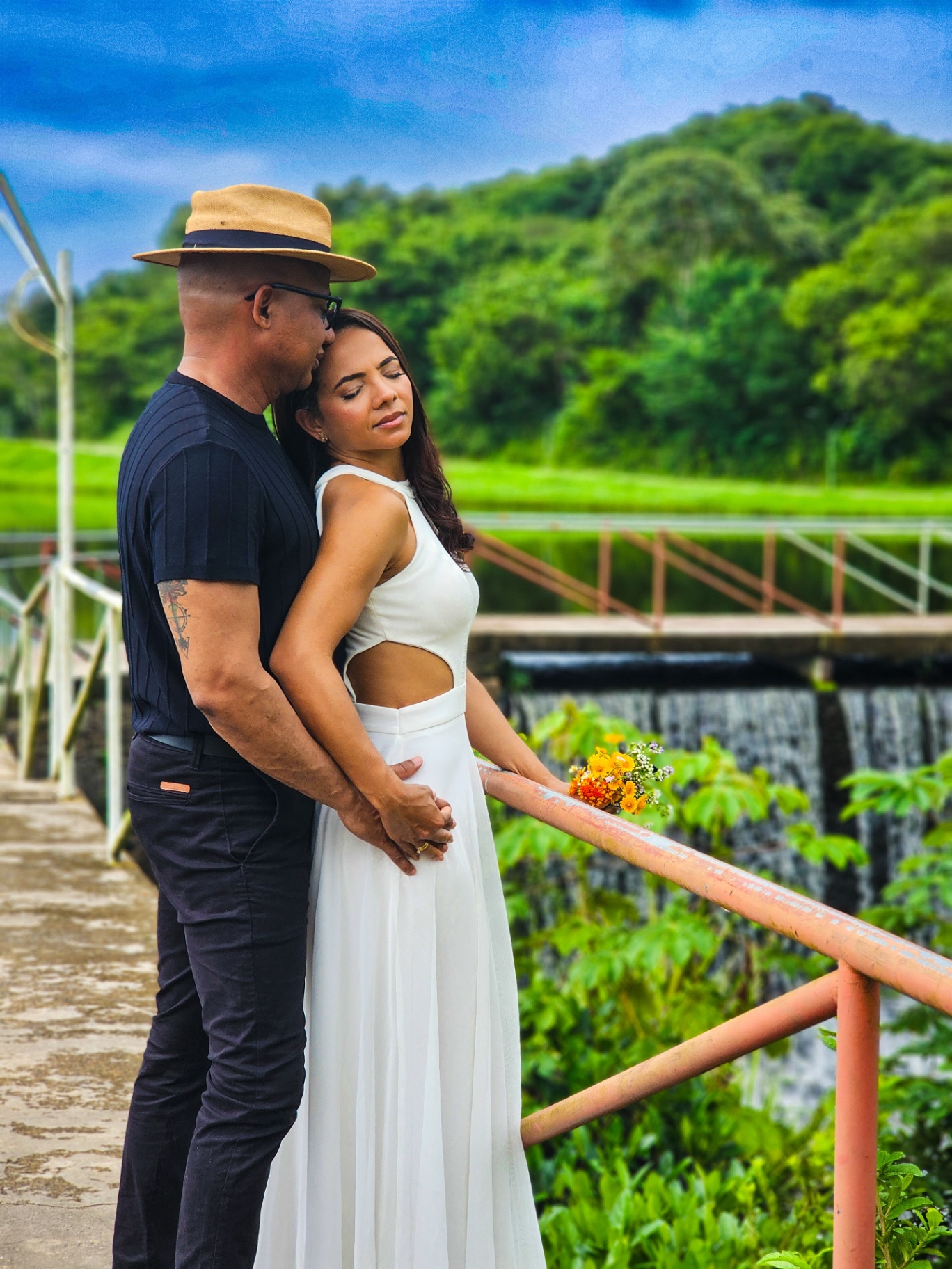 Casal abraçado junto à represa