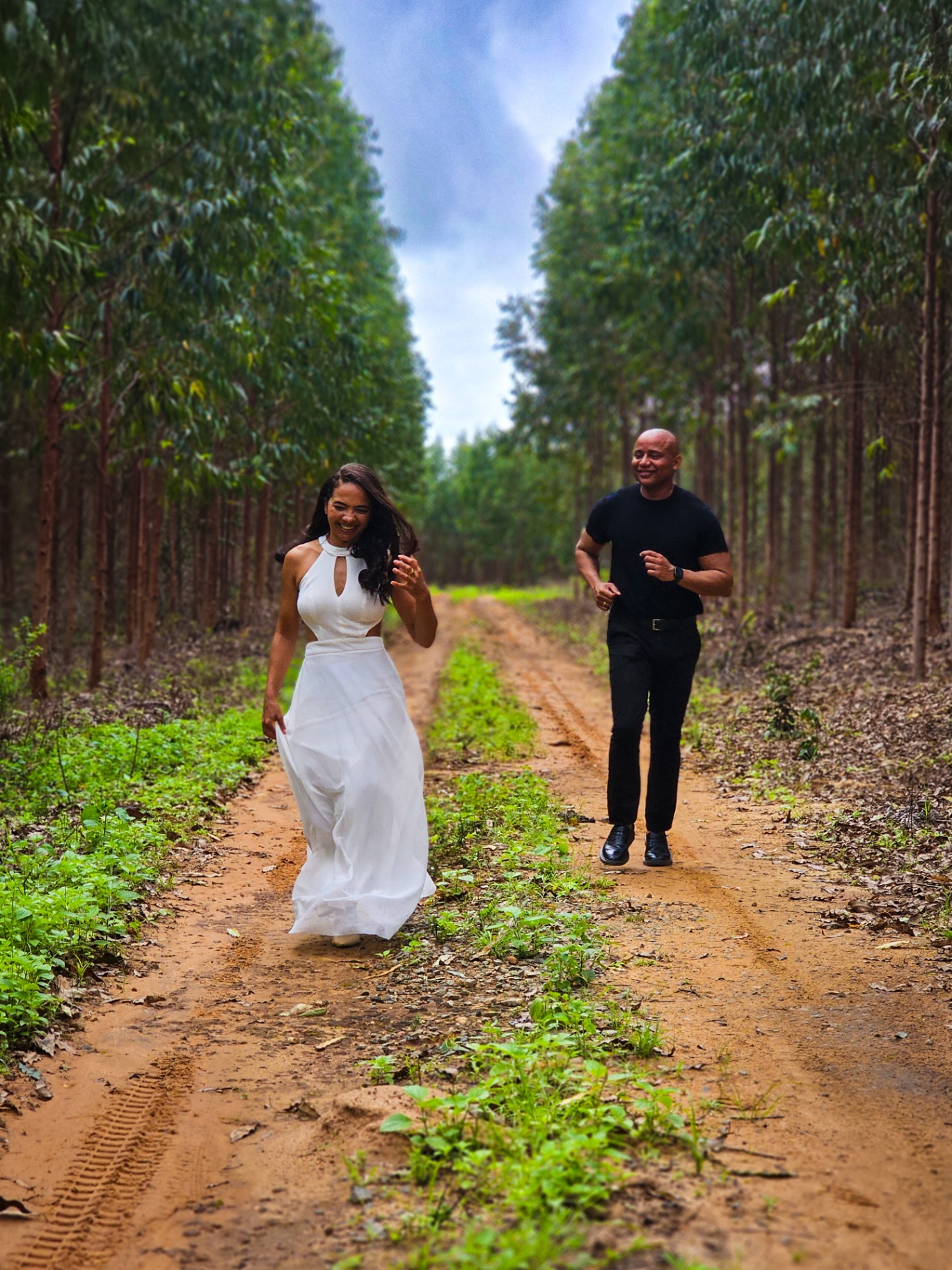Casal caminhando alegre pela trilha